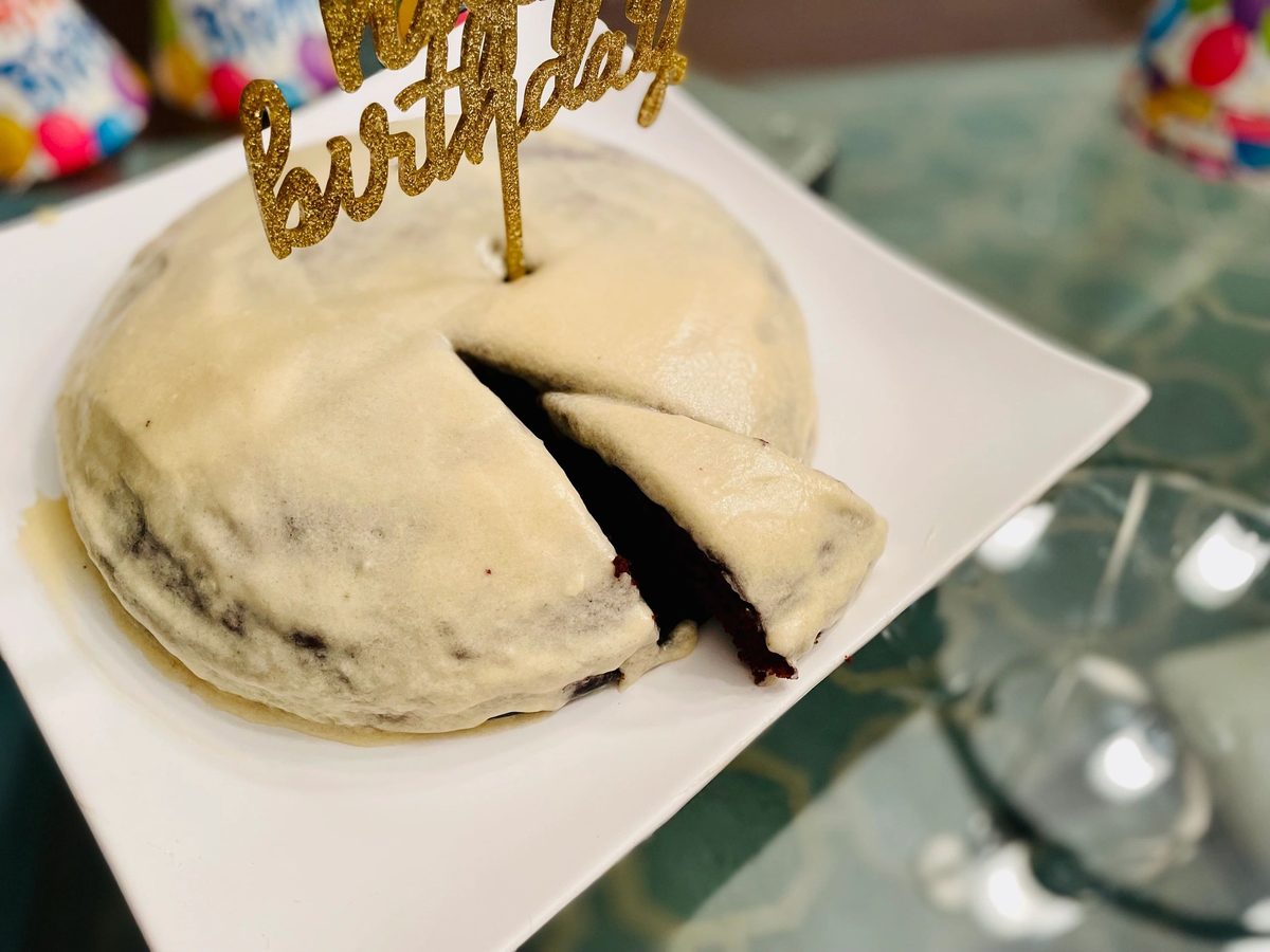 A small frosted birthday cake with a slice cut out