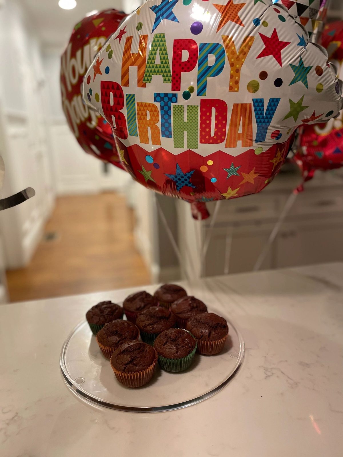 Chocolate cupcakes beside Happy Birthday balloons