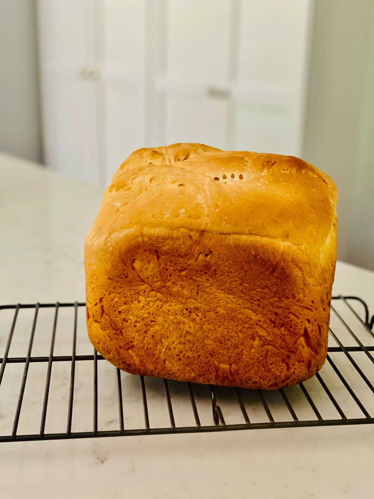 A homemade loaf cooling on a wire rack
