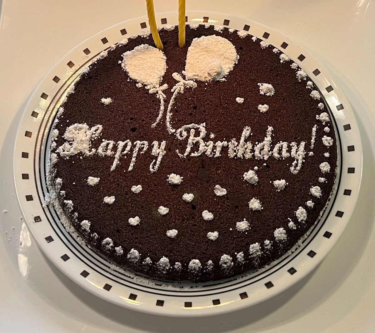 Chocolate cake with Happy Birthday piped in white
