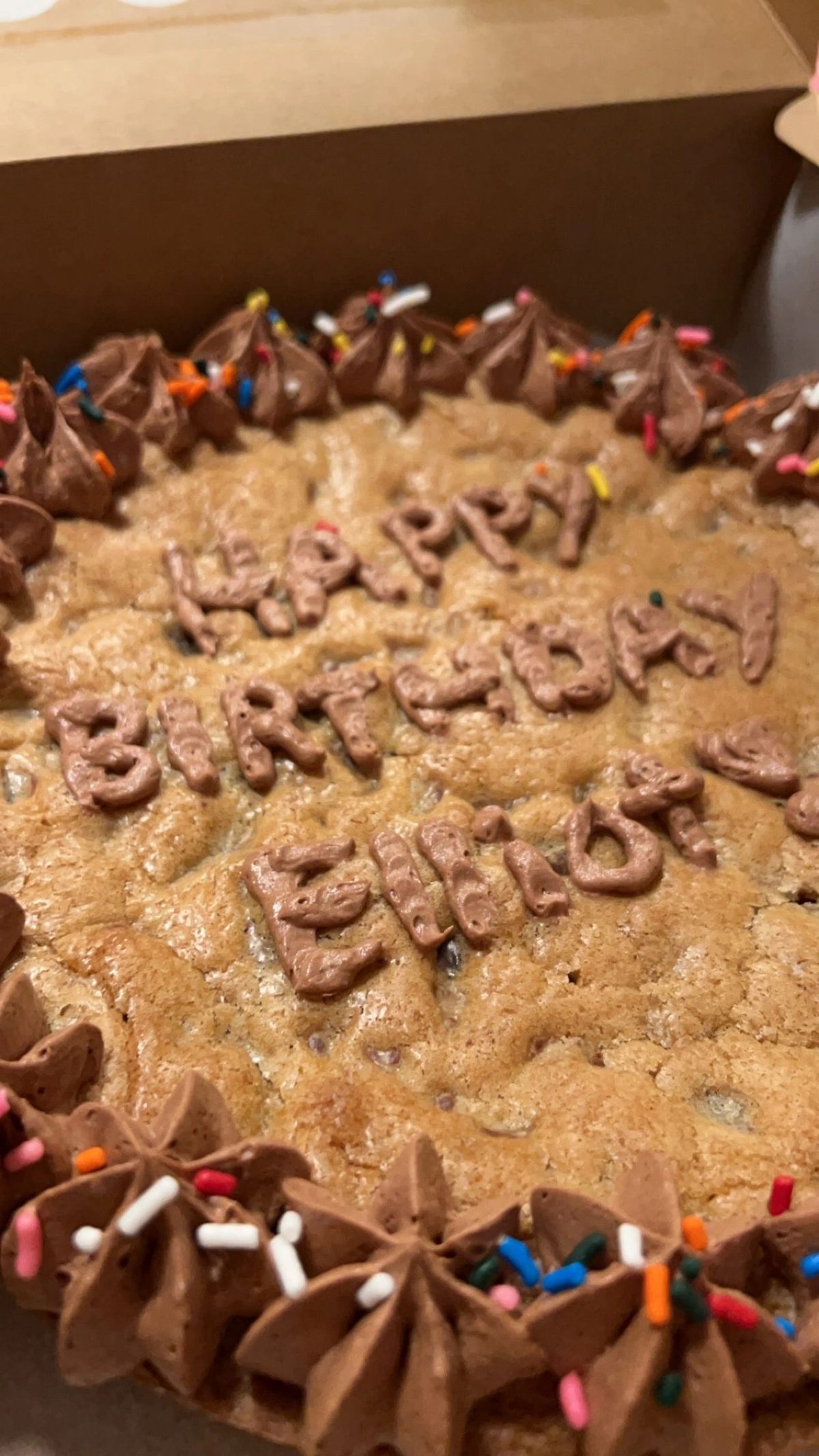 A chocolate chip cookie cake decorated with a birthday message