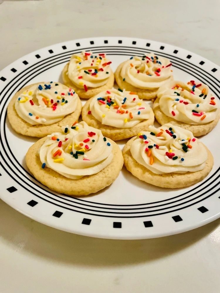 A platter of frosted sugar cookies with sprinkles