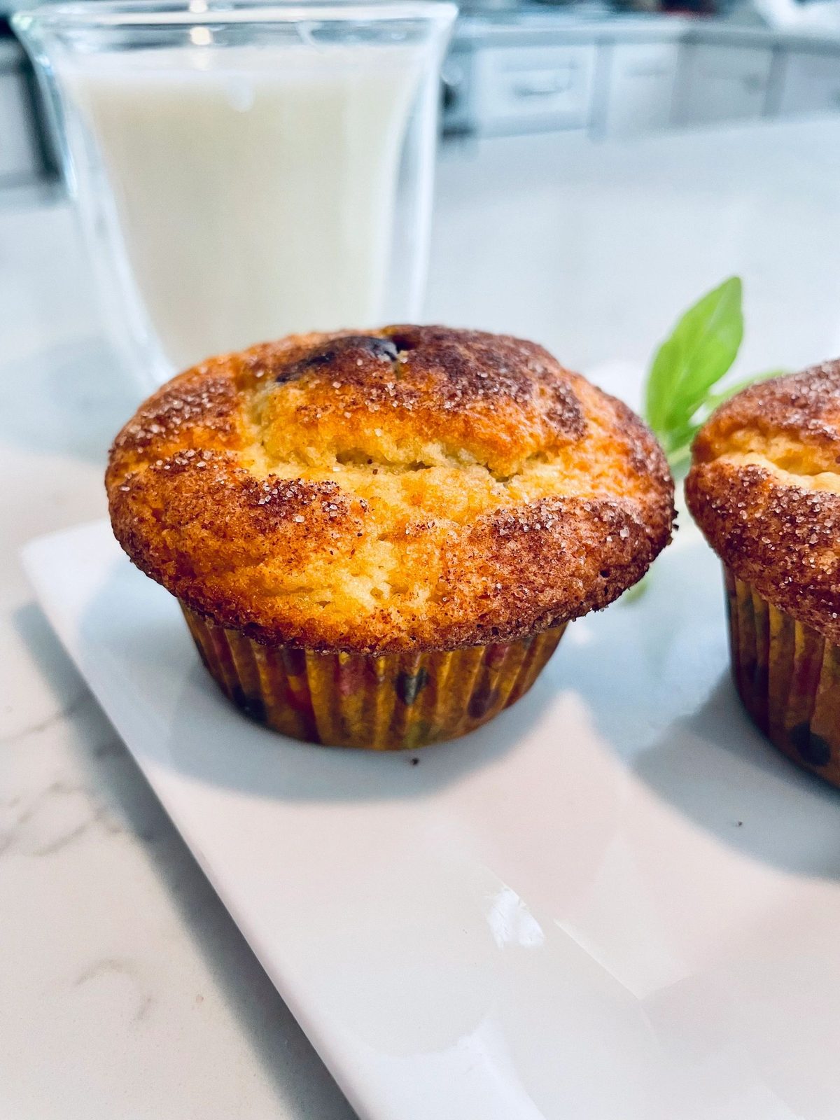 A sugar-topped muffin with a glass of milk