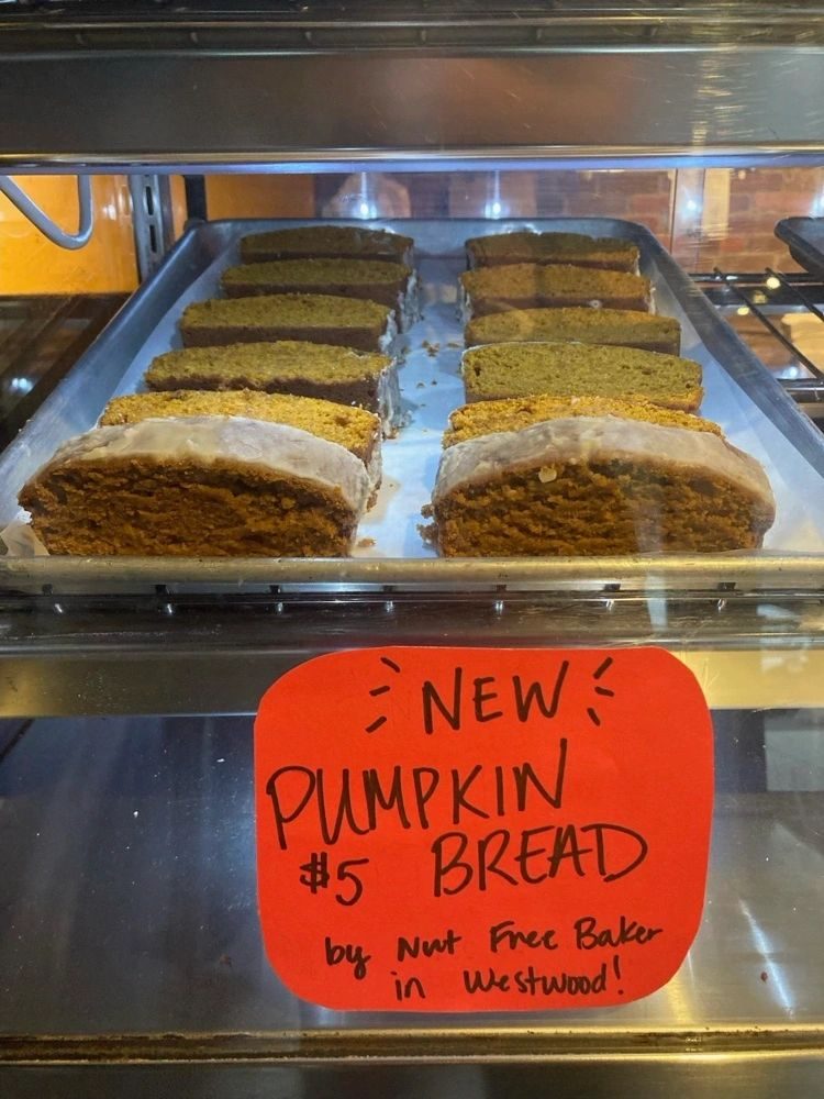 Iced pumpkin bread in a display case with a New Pumpkin Bread sign