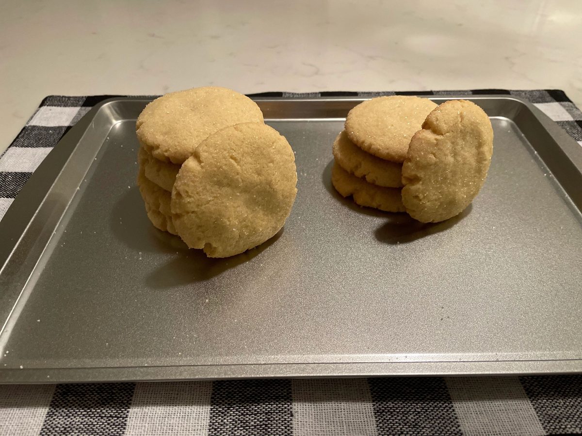 Sugar cookies stacked on a baking tray