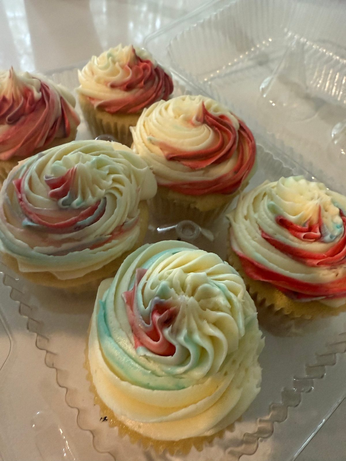Vanilla cupcakes with swirled red, blue and white frosting