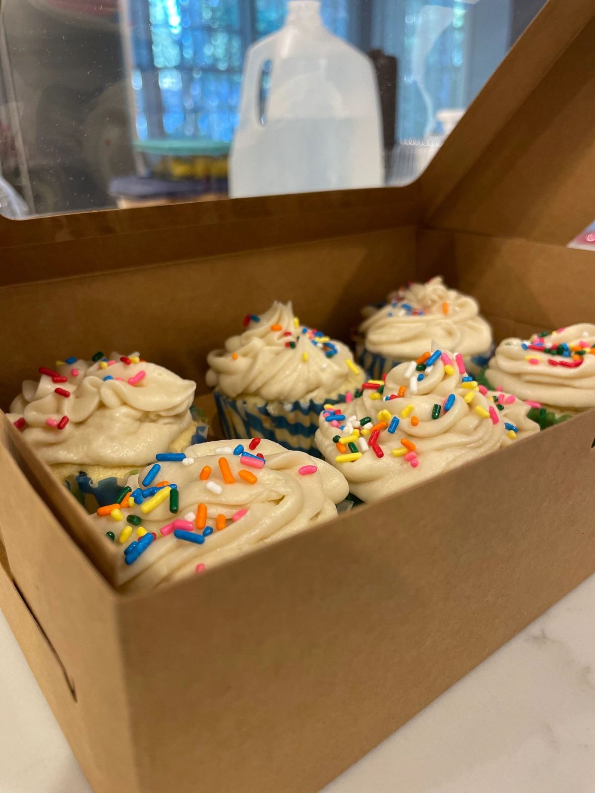 Vanilla cupcakes with sprinkles packed in a box
