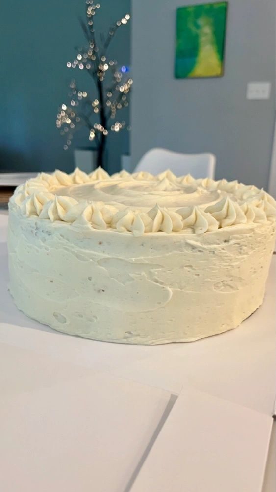 A tall vanilla layer cake finished in white buttercream